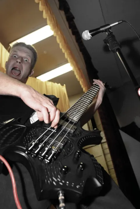 Close-up of a bass guitar being played.