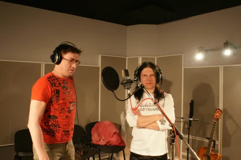 Working at a microphone in a recording room.