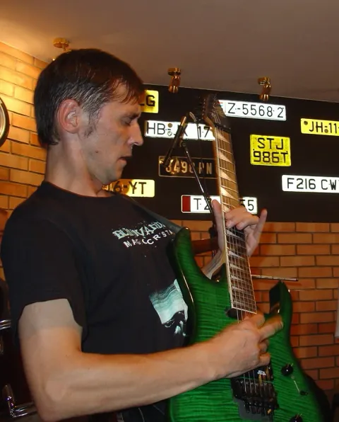 A guitarist beside the stage.